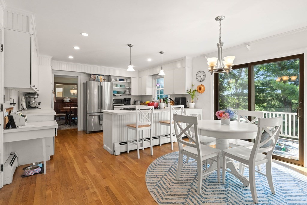 44 Crestwood Road Marblehead, MA 01945 - Photo 15 of 42 a kitchen with stainless steel appliances kitchen island granite countertop a refrigerator a stove top oven a dining table and chairs with wooden floor