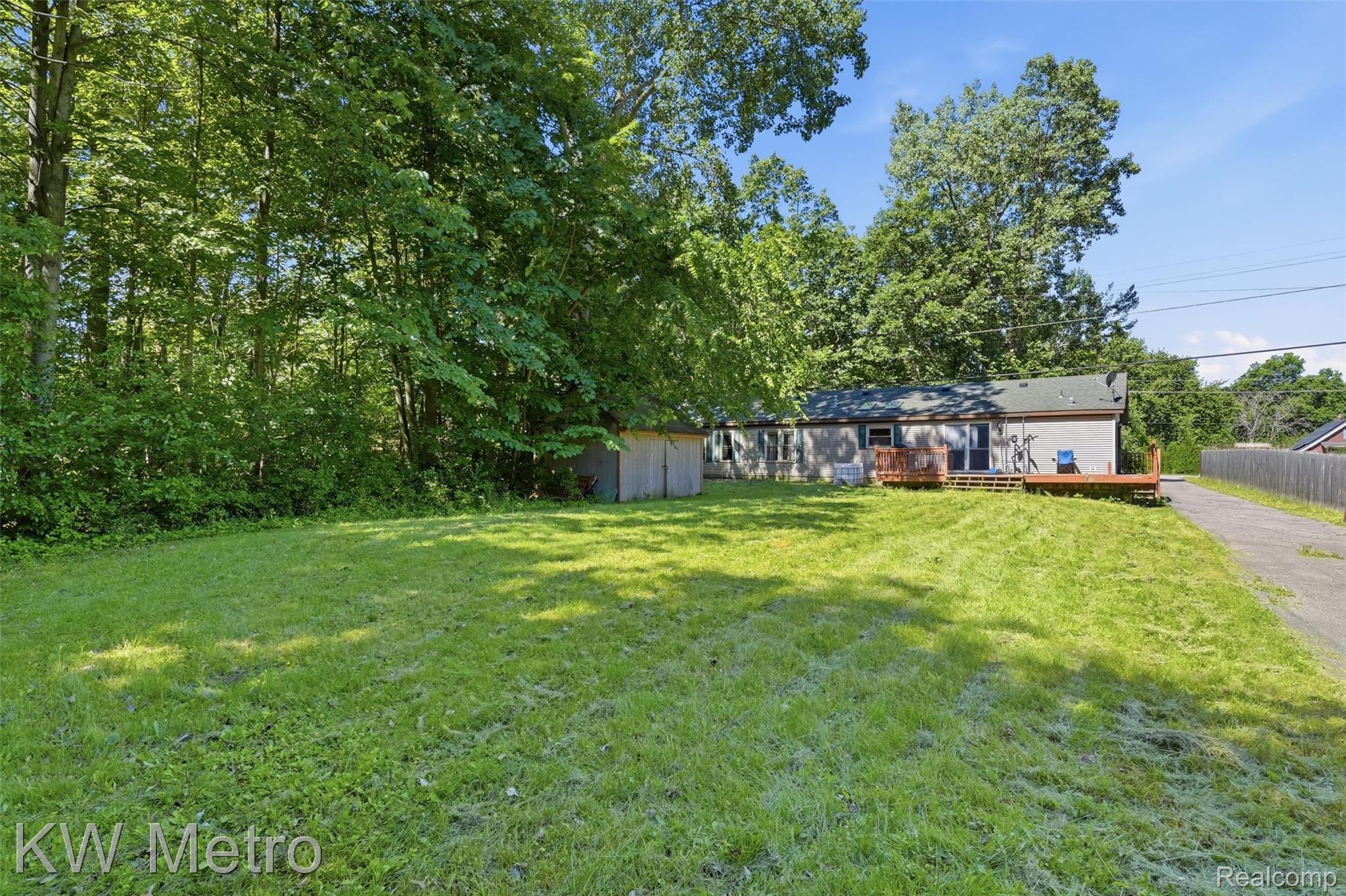 22733 Sumpter Road Belleville, MI 48111 - Photo 37 of 52 Expansive grassy yard with mature trees providing natural privacy