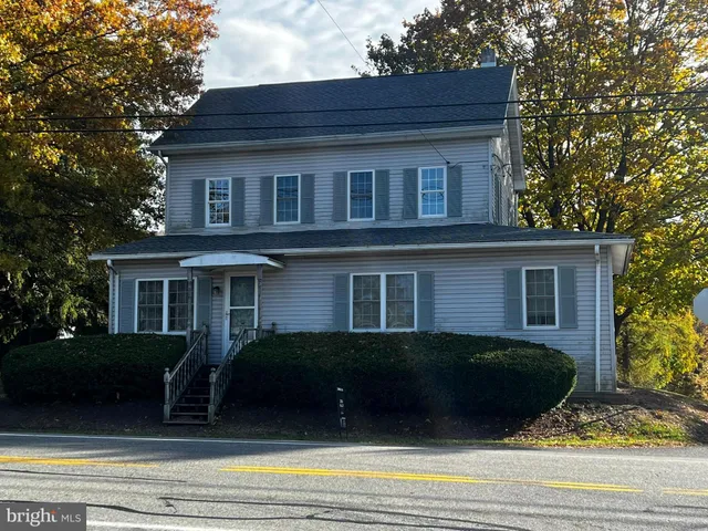 a view of a house with a deck and a yard
