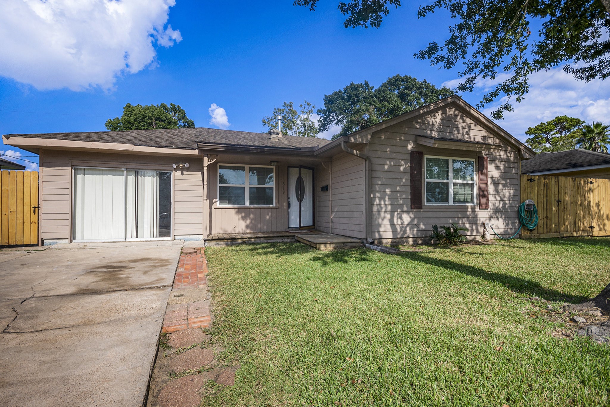 Charming and cozy single-story home with a welcoming front yard and ample driveway space.
