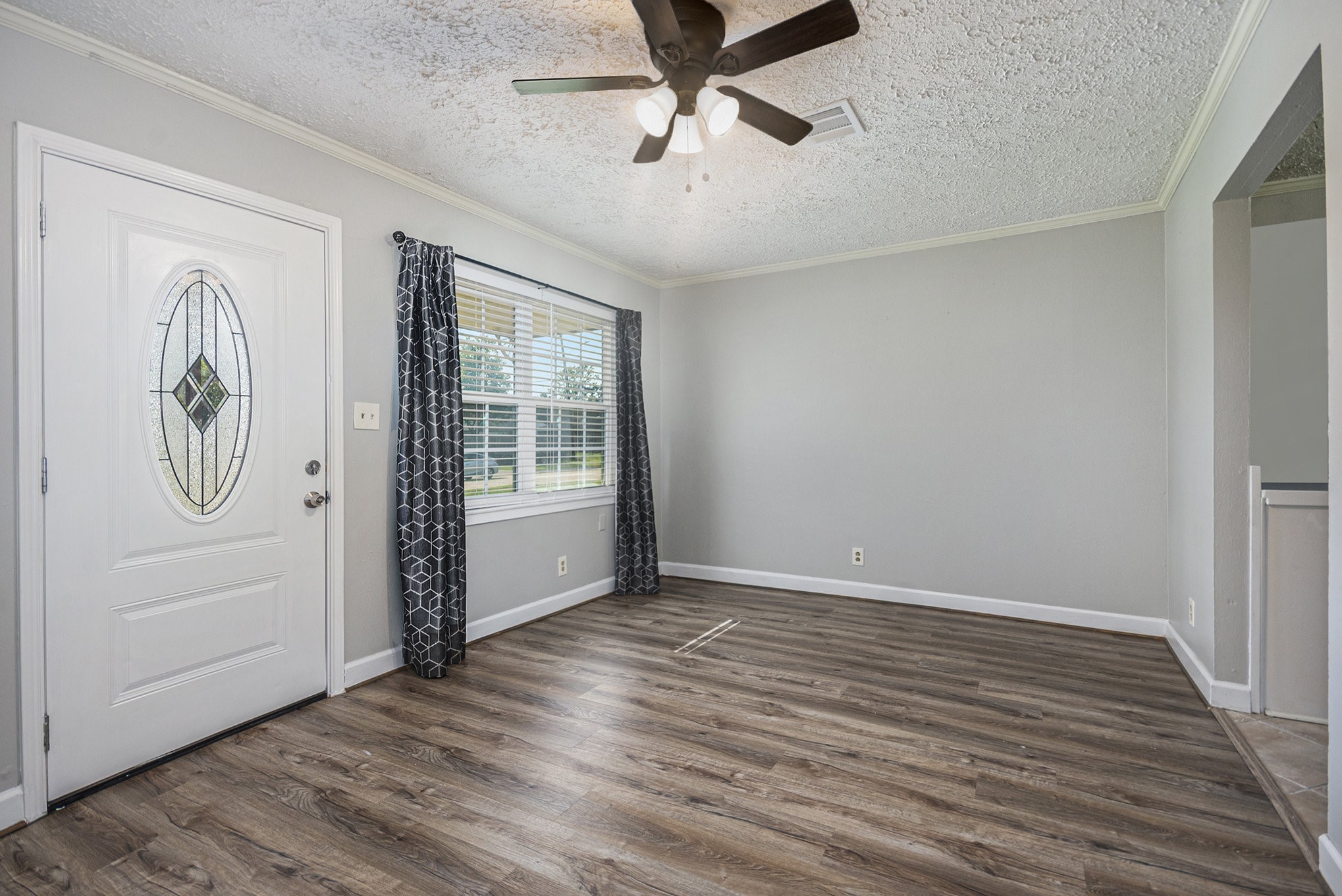 10619 Wheaton Drive Houston, TX 77089 - Photo 5 of 25 Bright and inviting entryway with stylish wood flooring and a decorative glass door. Ample natural light streams through large windows, creating a warm and welcoming atmosphere.
