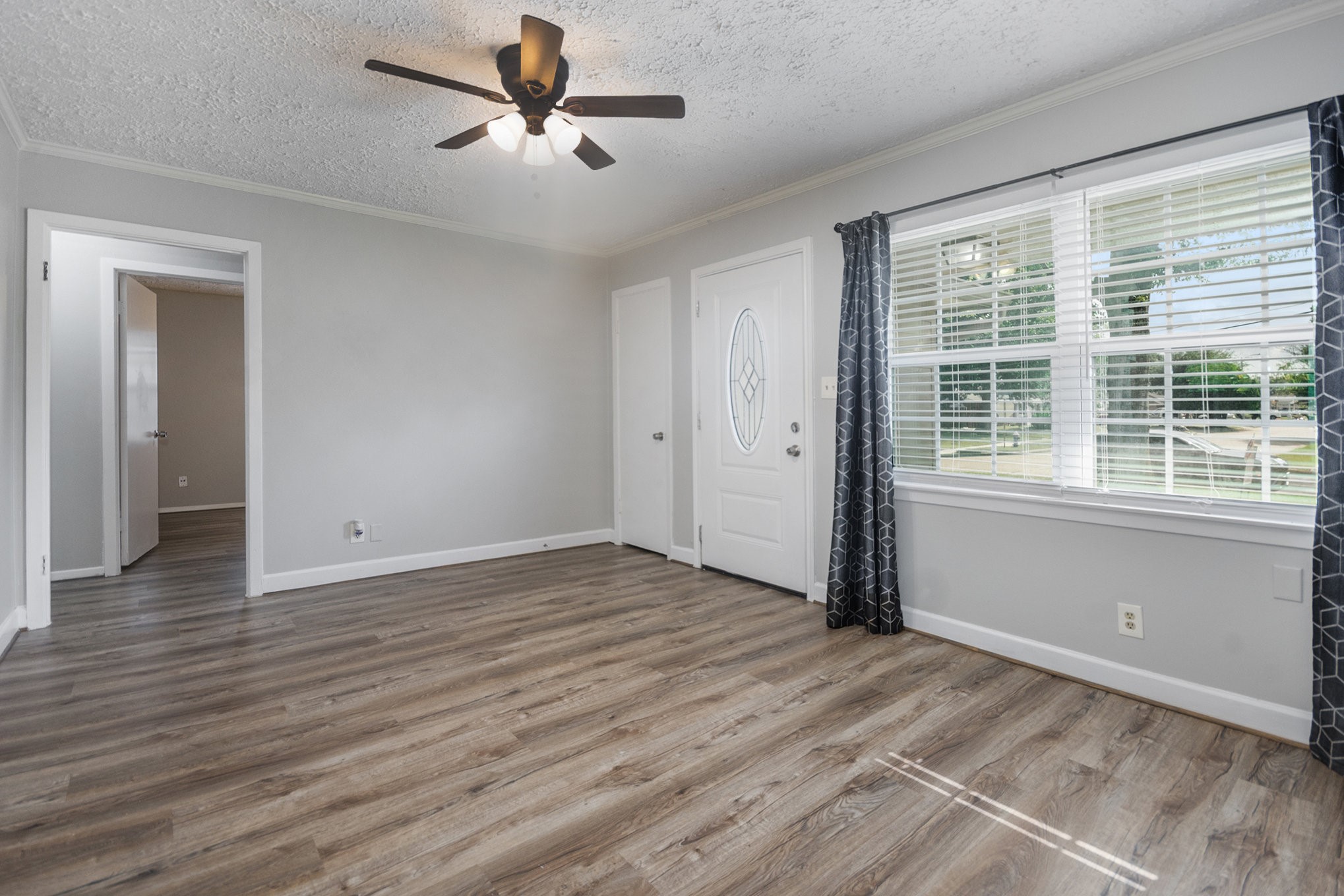 10619 Wheaton Drive Houston, TX 77089 - Photo 6 of 25 Welcome to a bright and inviting living space featuring elegant wood flooring, abundant natural light, and a stylish ceiling fan. Perfect for relaxation and entertaining.