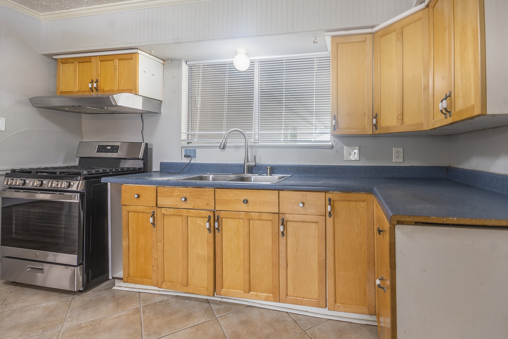 10619 Wheaton Drive Houston, TX 77089 - Photo 8 of 25 Charming kitchen featuring warm wood cabinets, sleek countertops, and a modern gas stove.