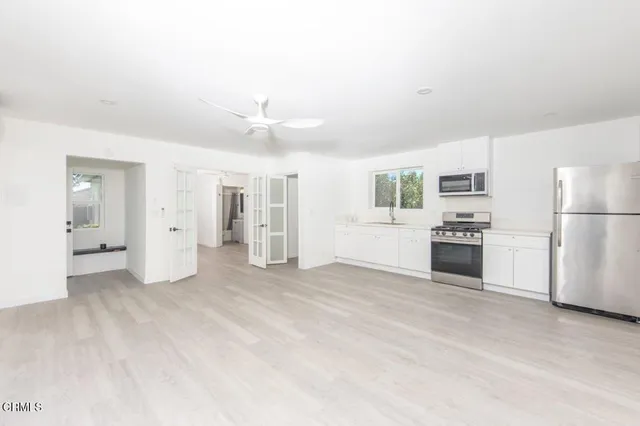a view of a kitchen with a sink stove refrigerator and cabinets