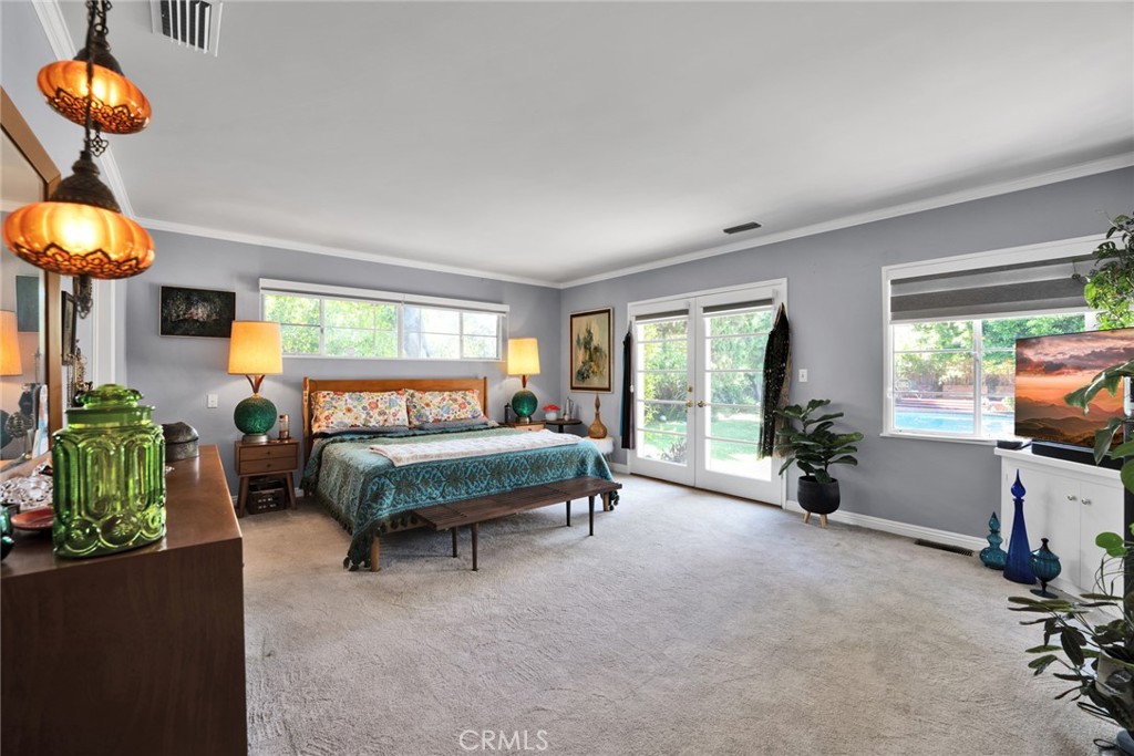 705 Chaucer Road San Marino, CA 91108 - Photo 17 of 35 a spacious bedroom with a bed and a chandelier