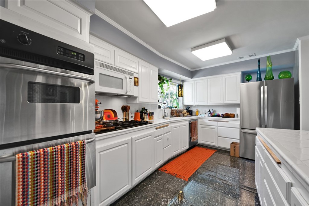 705 Chaucer Road San Marino, CA 91108 - Photo 7 of 35 a kitchen with stainless steel appliances kitchen island granite countertop a refrigerator and a stove top oven