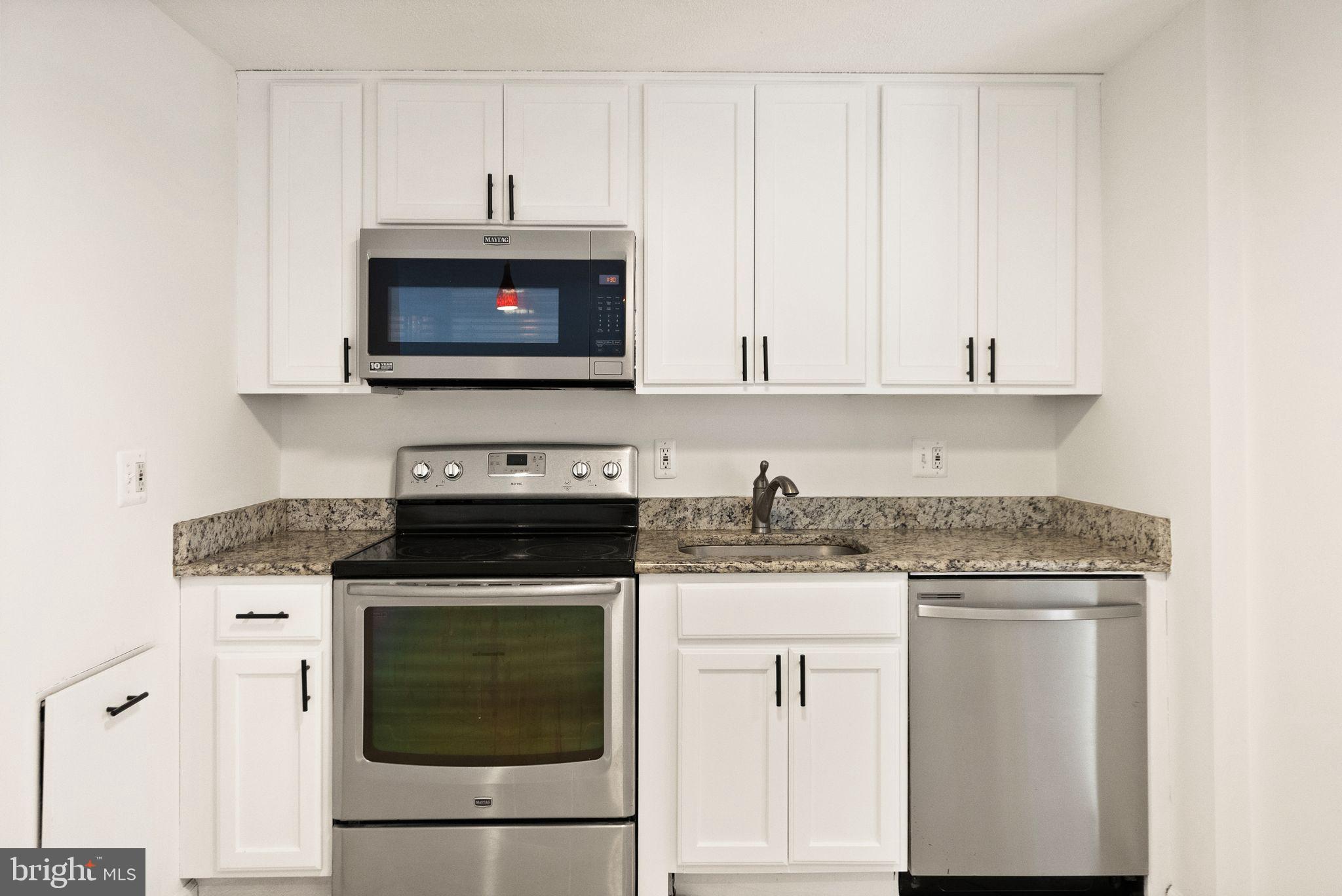 2280 Cocquina Drive Reston, VA 20191 - Photo 22 of 66 a kitchen with granite countertop a stove a sink and a white cabinets