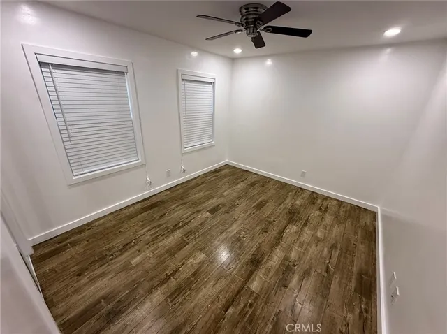 an empty room with a window and a ceiling fan