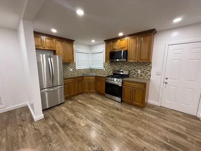 a kitchen with stainless steel appliances granite countertop a stove a sink and a refrigerator