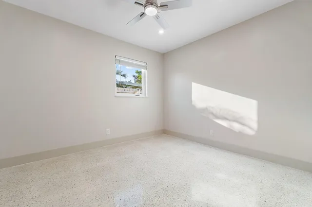 an empty room with a window and a ceiling fan
