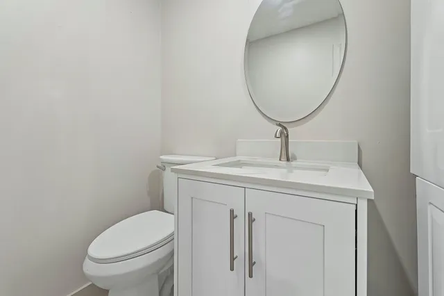 a bathroom with a sink a toilet and a mirror