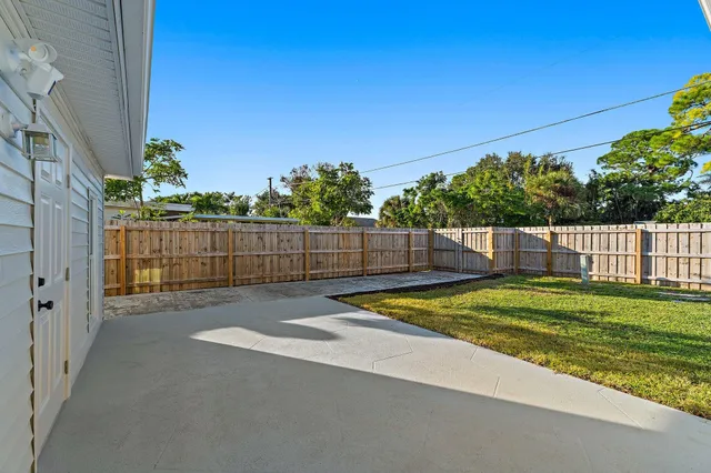 a view of backyard with wooden fence