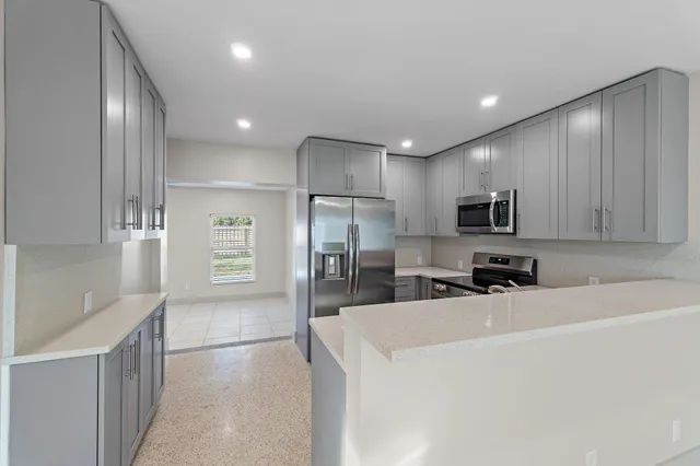 a kitchen with stainless steel appliances a refrigerator sink and microwave
