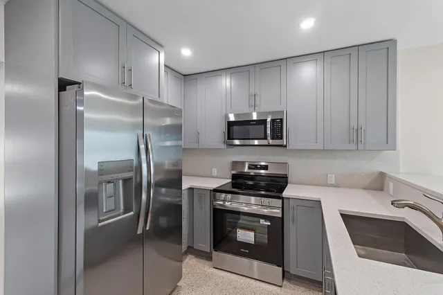 a kitchen with stainless steel appliances granite countertop a refrigerator stove and sink