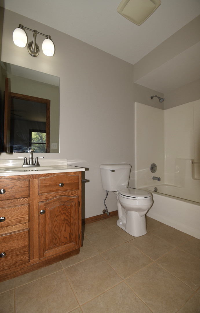 406 Garfield Road Fox Lake, IL 60041 - Photo 13 of 33 a spacious bathroom with a toilet sink and mirror