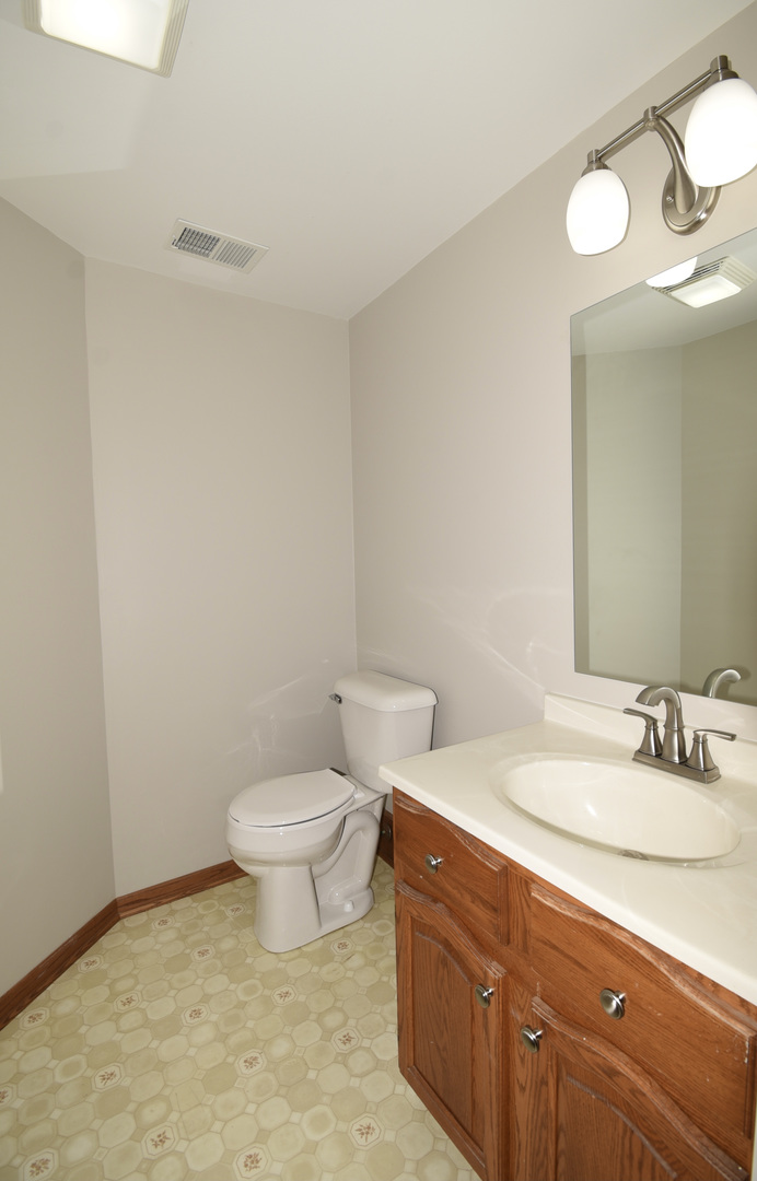 406 Garfield Road Fox Lake, IL 60041 - Photo 24 of 33 a bathroom with a granite countertop sink a toilet and a mirror
