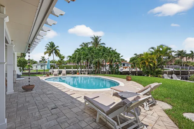 a view of a balcony with two chairs potted plants and a palm tree
