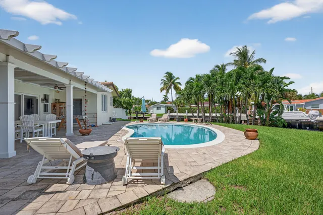 a view of a house with backyard and sitting area