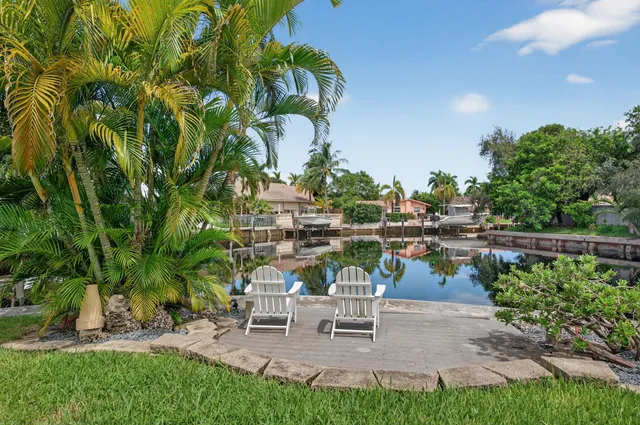 an aerial view of a residential houses with outdoor space and trees