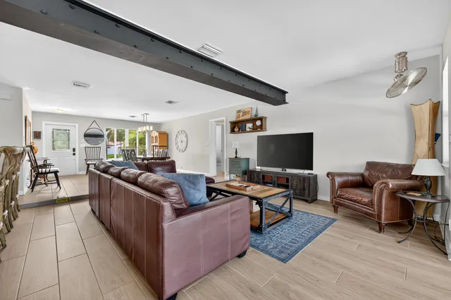 a kitchen with stainless steel appliances kitchen island granite countertop a stove a sink and a wooden floors