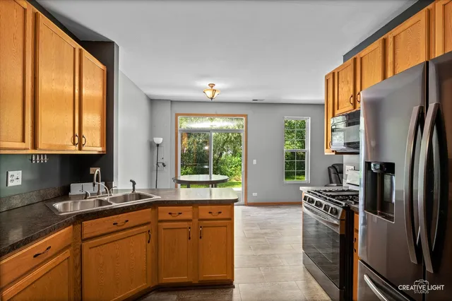 a kitchen with stainless steel appliances a refrigerator sink and cabinets