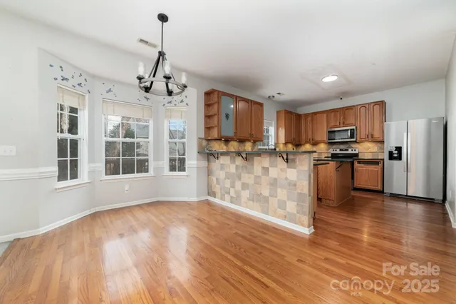 a view of kitchen with granite countertop cabinets and refrigerator