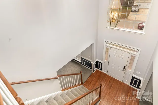 a view of staircase with railing and white walls