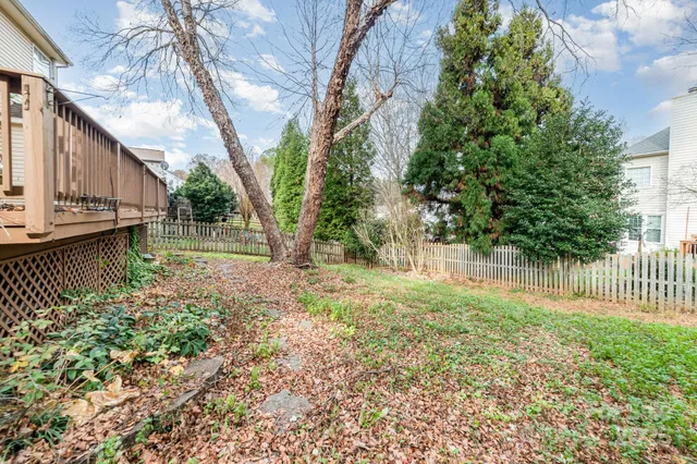 a view of a house with backyard and trees