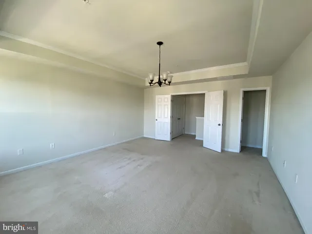 a view of a room with a ceiling fan and entryway
