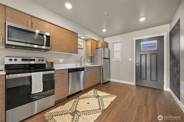 a kitchen with stainless steel appliances a stove a microwave and white cabinets