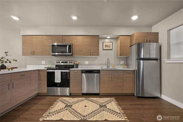 a kitchen with granite countertop a refrigerator and a stove top oven
