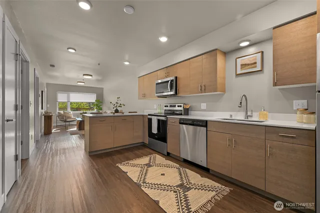 a large kitchen with stainless steel appliances granite countertop a lot of counter space and wooden floors