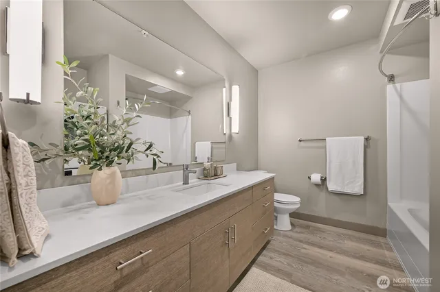 a bathroom with a sink a toilet and shower