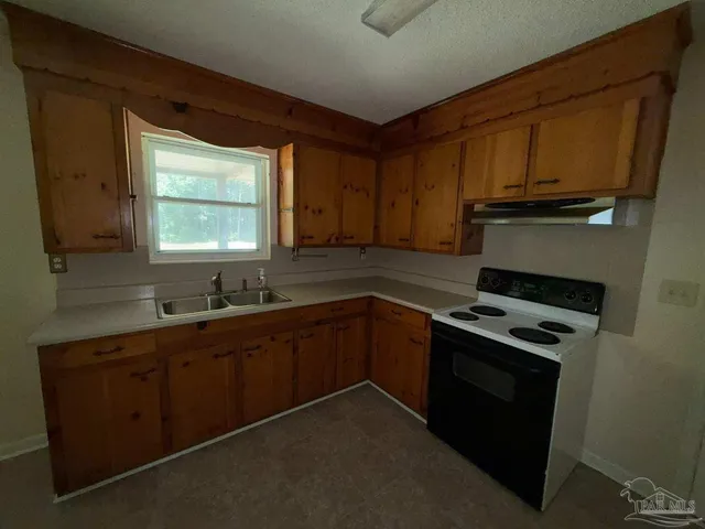a kitchen with wooden cabinets and a stove top oven