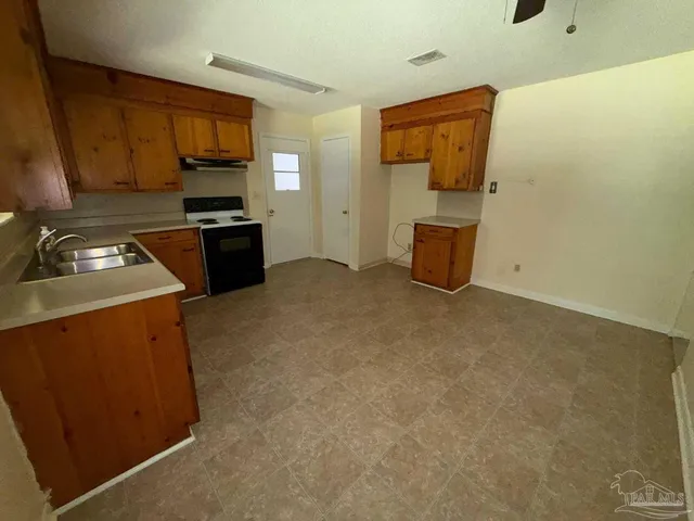 a kitchen with a refrigerator and a stove top oven