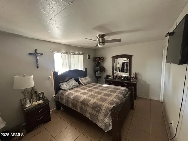 a bedroom with a bed flat screen tv and window