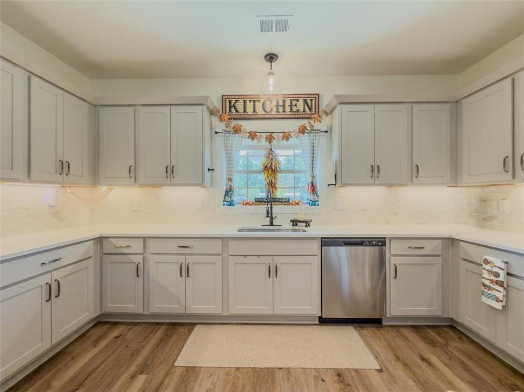 710 Poplar Street Monroe, GA 30655 - Photo 11 of 60 a kitchen with stainless steel appliances granite countertop a sink and cabinets