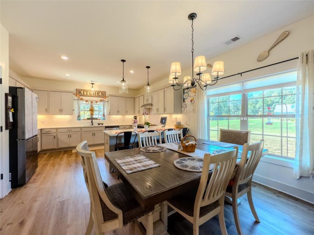 710 Poplar Street Monroe, GA 30655 - Photo 18 of 60 a view of a dining room and livingroom with furniture wooden floor a chandelier