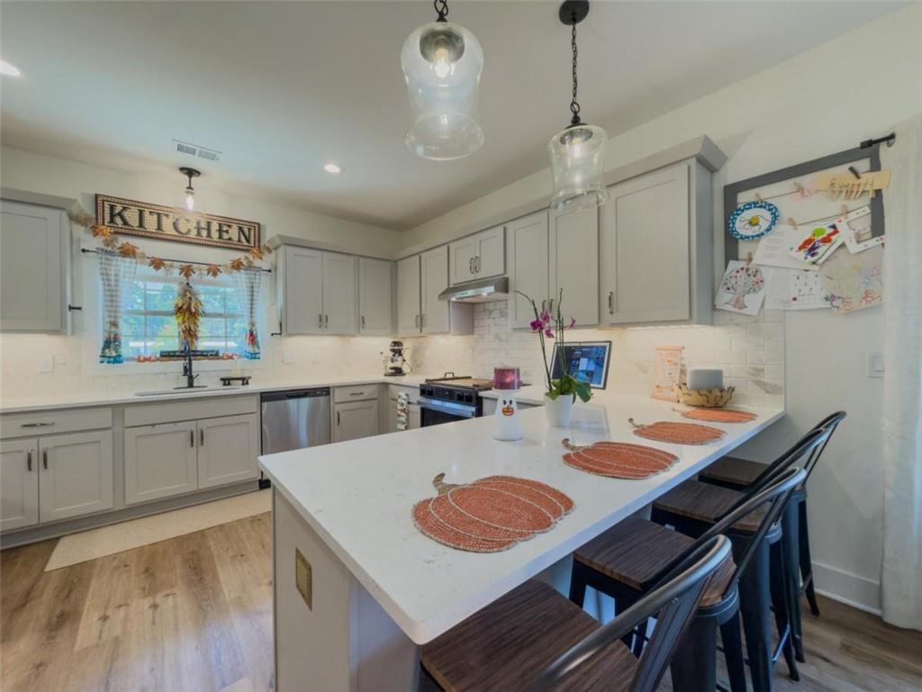 710 Poplar Street Monroe, GA 30655 - Photo 2 of 60 a kitchen with a dining table cabinets stainless steel appliances and a dining table
