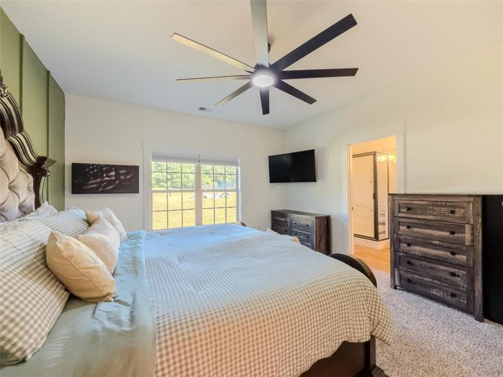 710 Poplar Street Monroe, GA 30655 - Photo 26 of 60 a bedroom with a bed and a flat tv screen on a dresser
