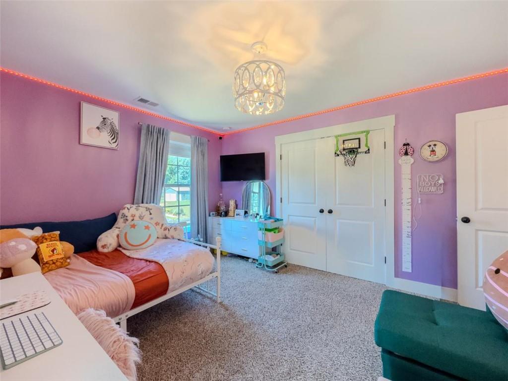 710 Poplar Street Monroe, GA 30655 - Photo 41 of 60 a bedroom with two beds and a chandelier