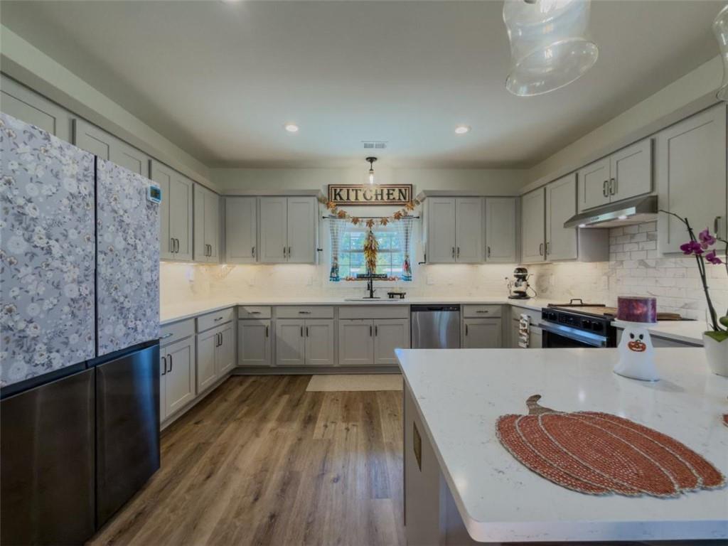 710 Poplar Street Monroe, GA 30655 - Photo 10 of 60 a kitchen with stainless steel appliances granite countertop a sink dishwasher stove refrigerator and cabinets with wooden floor