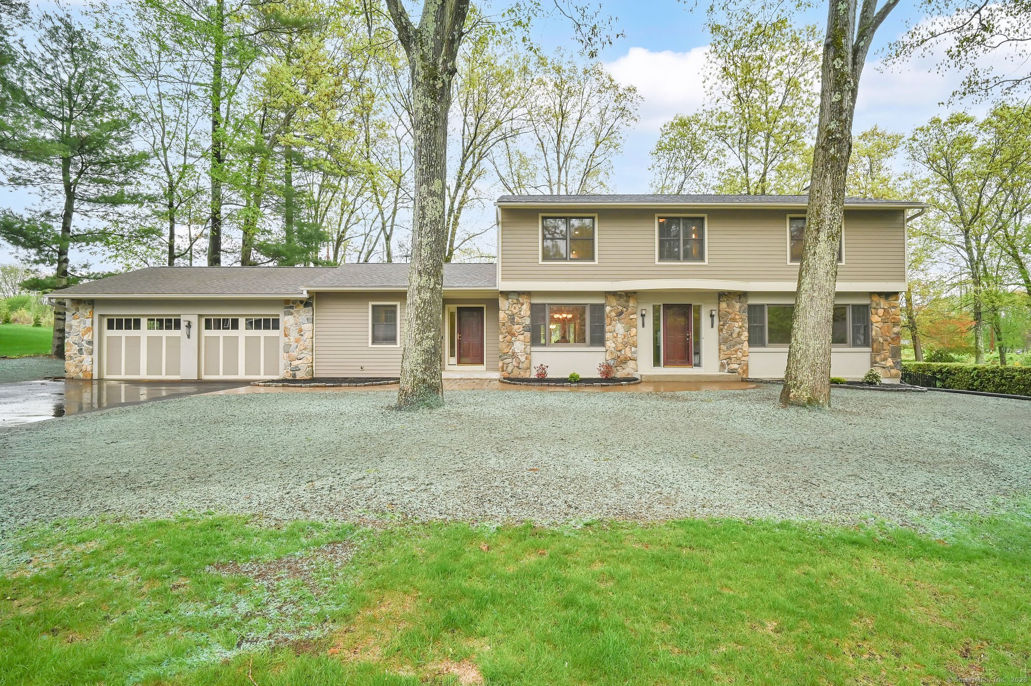 a view of a yard in front of a house with large windows