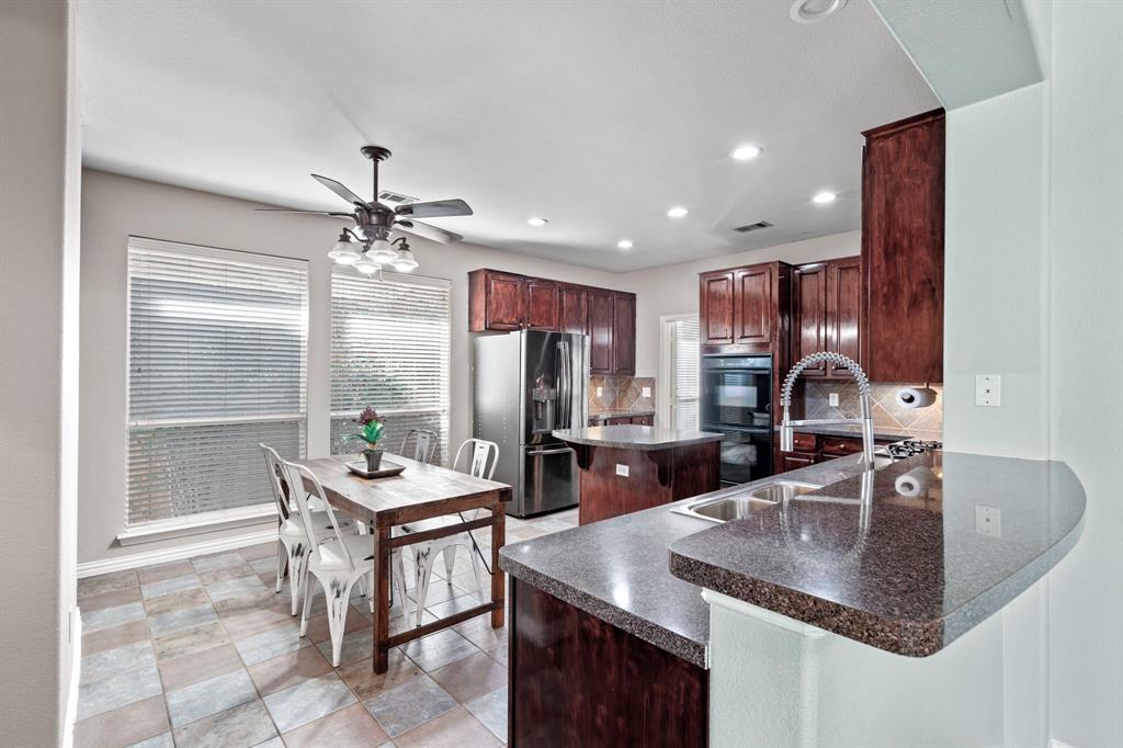 1105 Lamplight Way Allen, TX 75013 - Photo 15 of 40 a kitchen with kitchen island granite countertop a sink a counter top space and stainless steel appliances