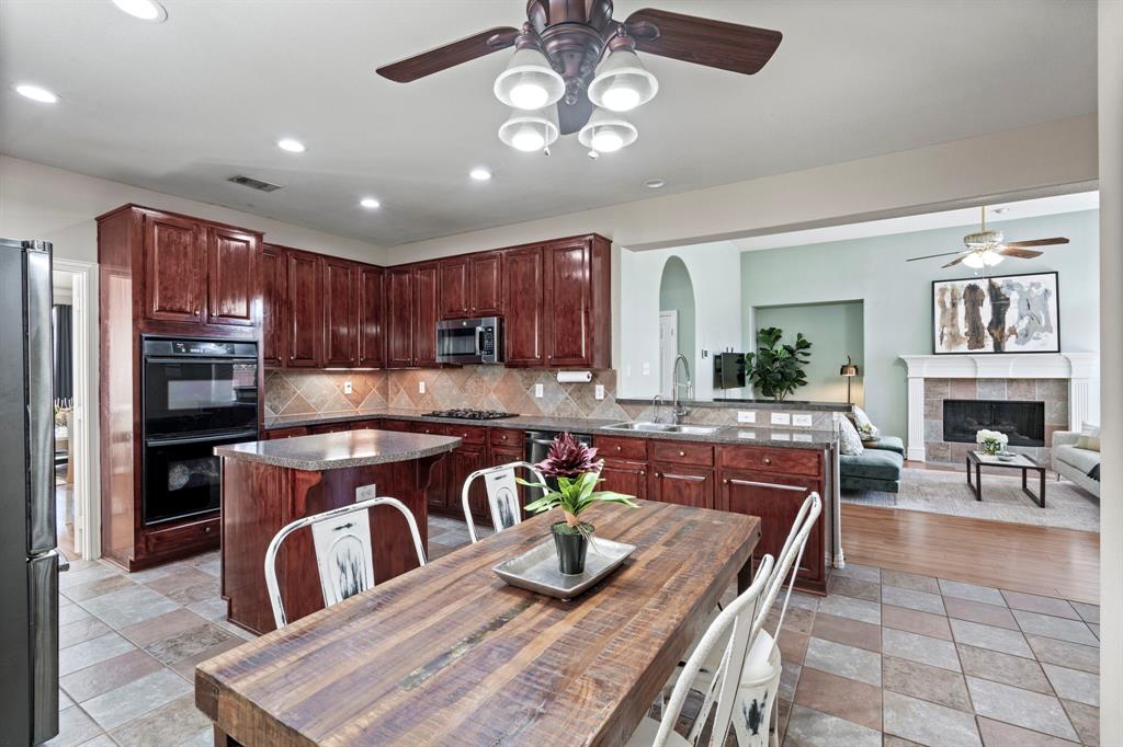 1105 Lamplight Way Allen, TX 75013 - Photo 16 of 40 a kitchen with a table chairs refrigerator and stove