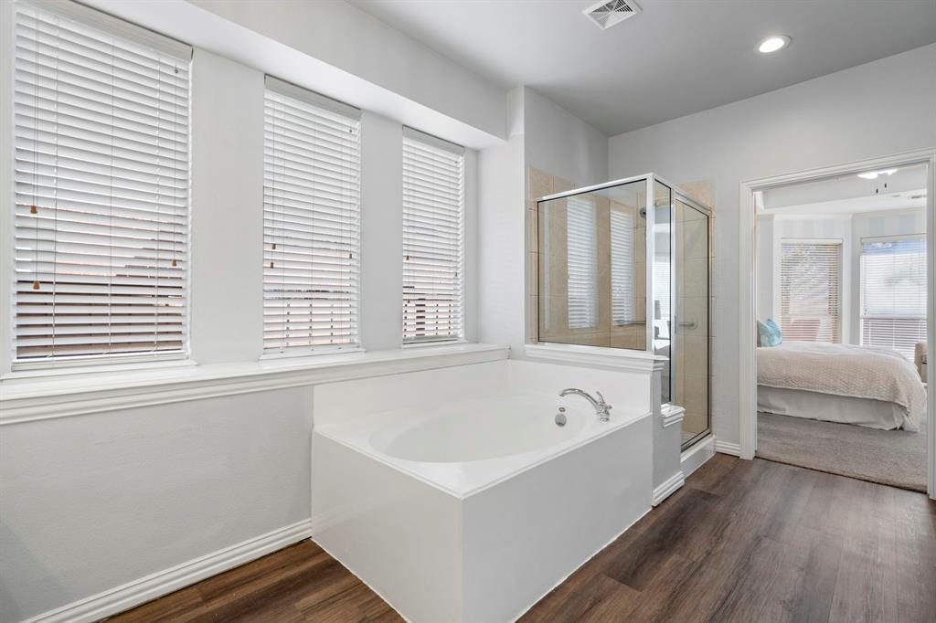 1105 Lamplight Way Allen, TX 75013 - Photo 25 of 40 a white bath tub sitting in a spacious bathroom next to a window