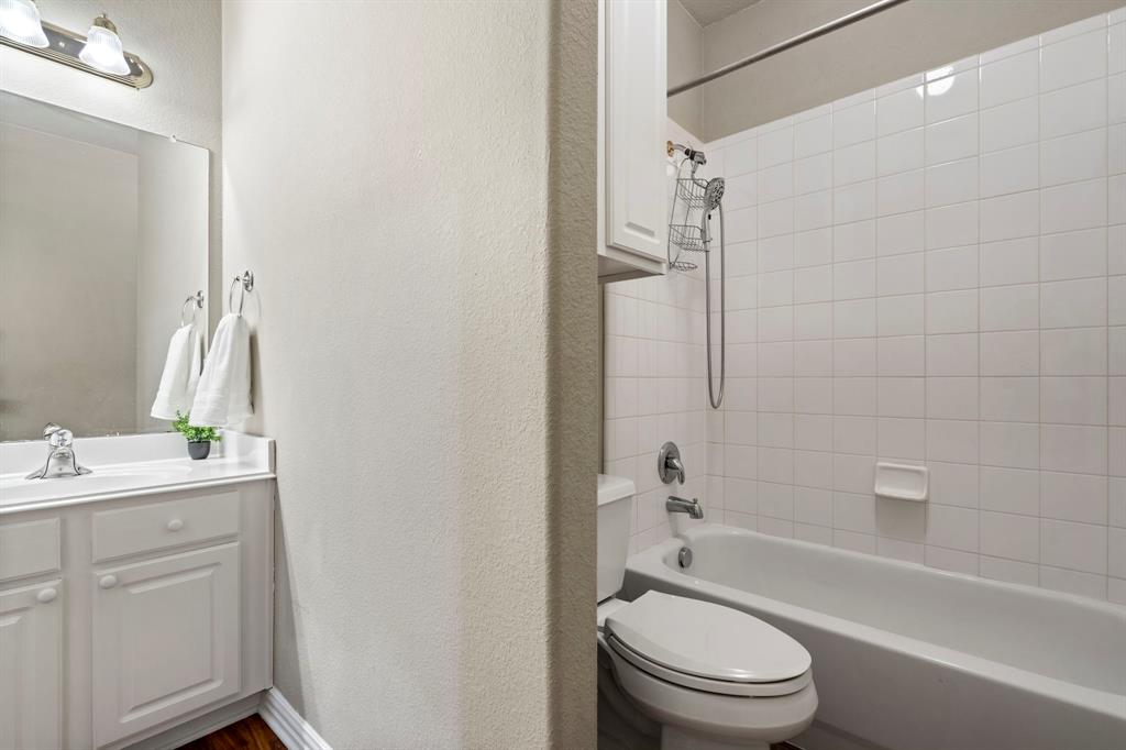 1105 Lamplight Way Allen, TX 75013 - Photo 33 of 40 a bathroom with a granite countertop toilet a sink and a bathtub