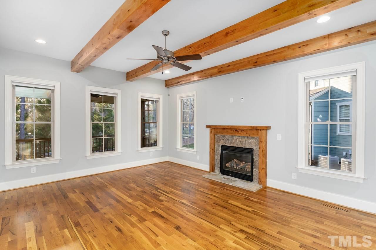 8505 Wynhurst Court Raleigh, NC 27613 - Photo 11 of 30 a view of an empty room with wooden floor fireplace and a window