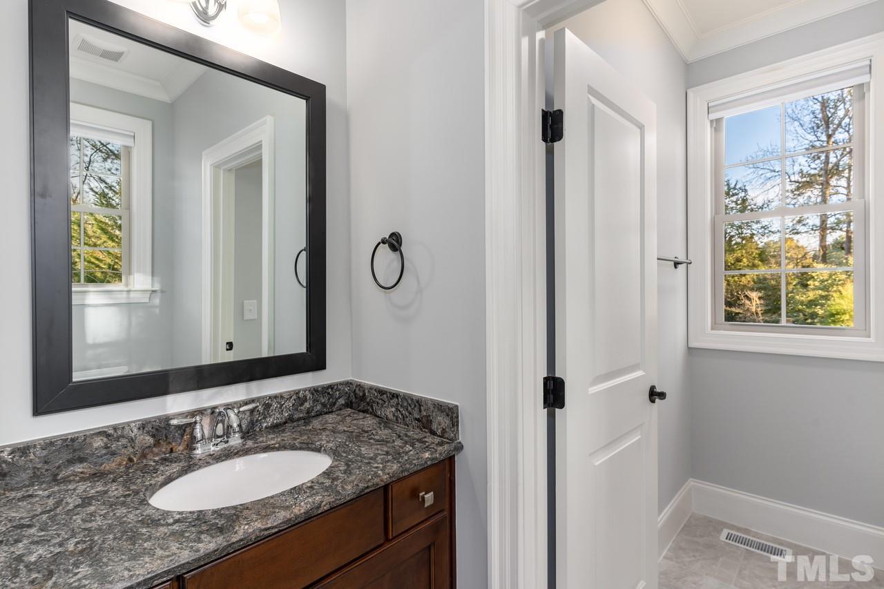 8505 Wynhurst Court Raleigh, NC 27613 - Photo 18 of 30 a bathroom with a granite countertop sink and a mirror