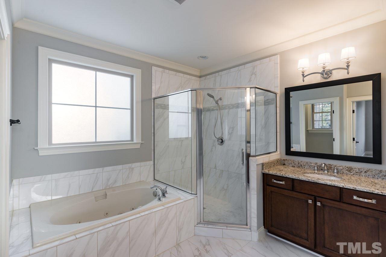 8505 Wynhurst Court Raleigh, NC 27613 - Photo 5 of 30 a bathroom with a tub a sink and a large mirror